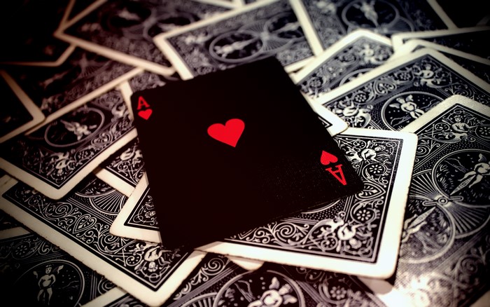 Ace of Hearts card on a pile of playing cards
