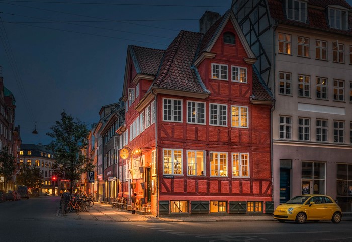 Red timber-framed houses on a street in Copenhagen at night
