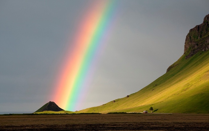Rainbow over a green mountain landscape