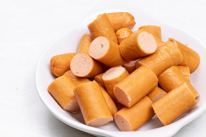 Many Vienna sausages in a white plate