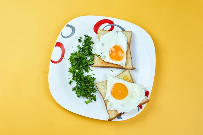 Fried eggs on toast with dill on a plate