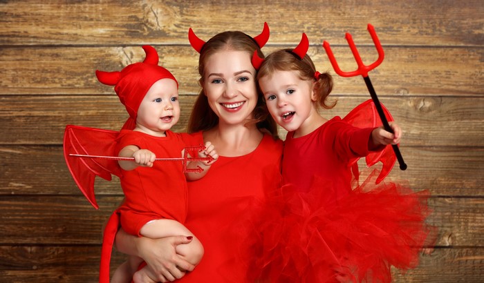 Mother and two children in devil costumes