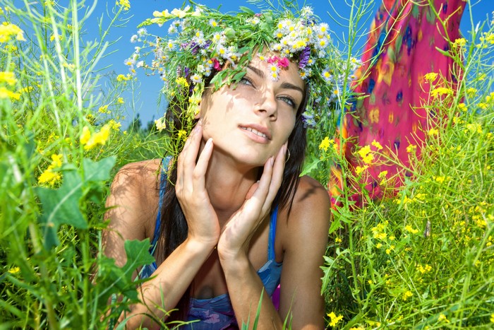 Woman with flower wreath in a field