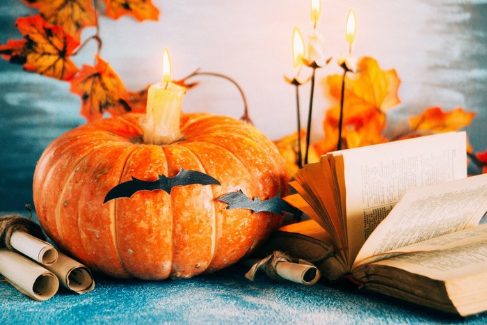 Halloween pumpkin with candles and books