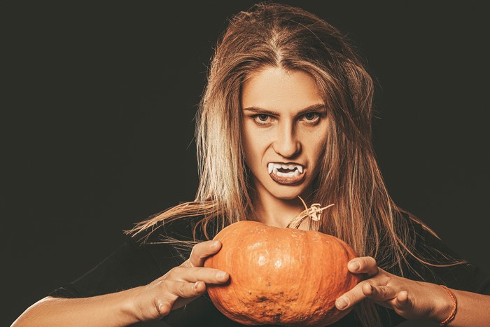 Woman with fangs and pumpkin