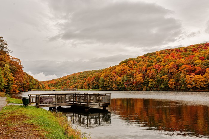 Autumn foliage over a lake with a wooden pier in Norton, Virginia