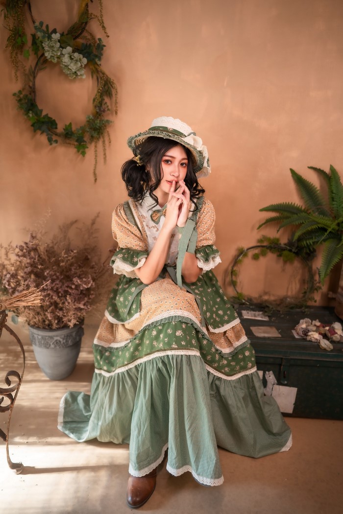 Asian woman in retro dress and hat sitting