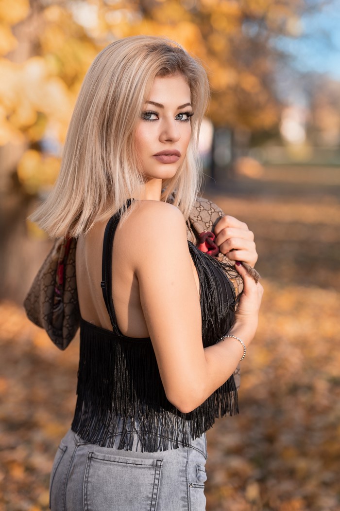 Blonde woman with Gucci scarf in autumn park