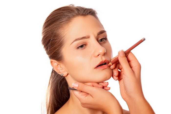 Woman applying lip liner with pencil