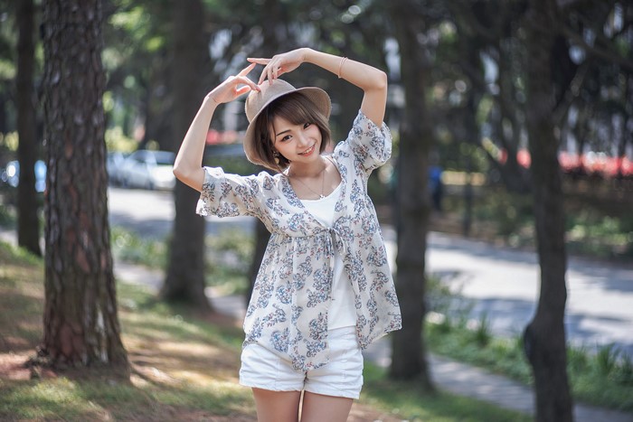 Asian woman in hat posing outdoors