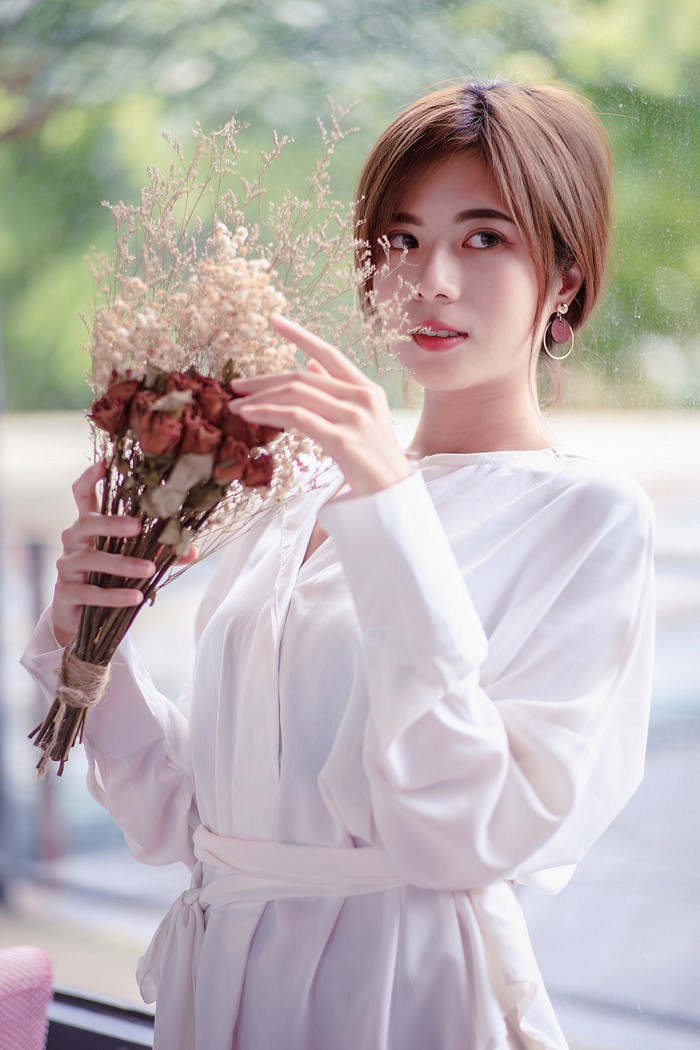 Asian woman holding a bouquet of dried flowers