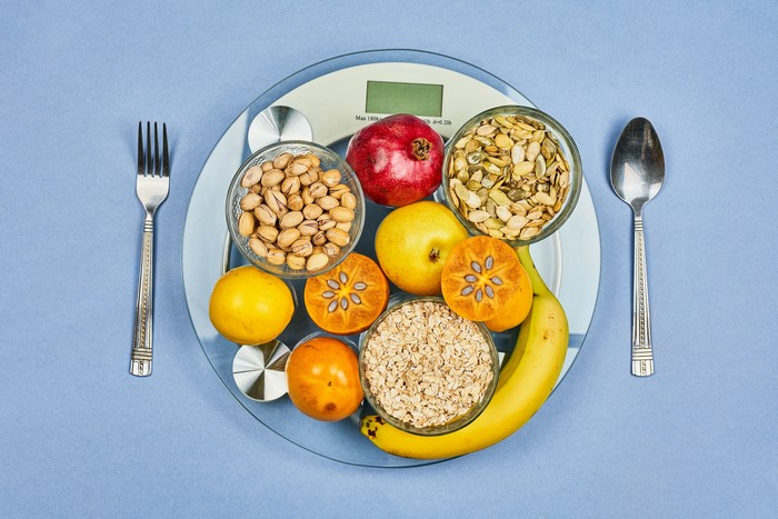 Healthy food assortment on a scale with fork and spoon