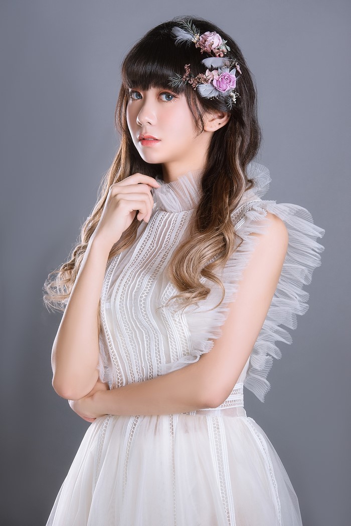 Asian woman in white dress with flower crown