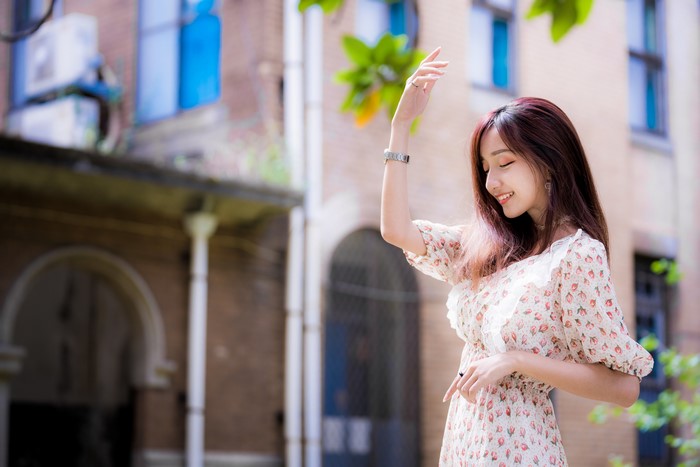 Asian woman in floral dress posing outdoors