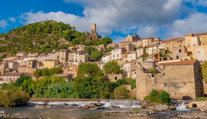 Roquebrun village with castle ruins and river in France