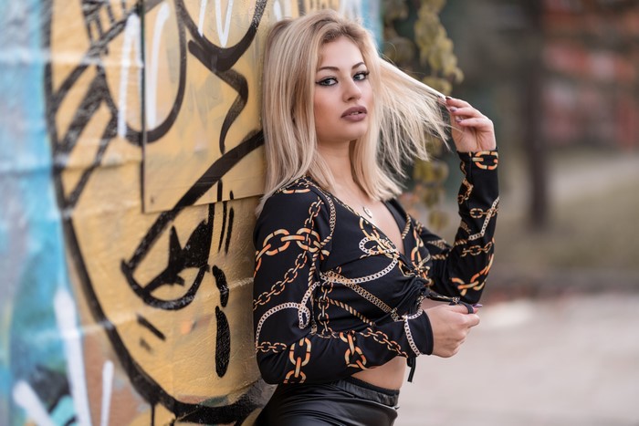 Blonde girl posing near graffiti wall