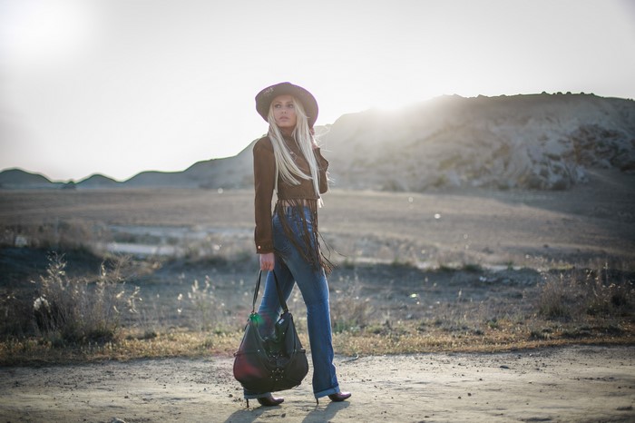 Blonde girl in hat and jeans with handbag