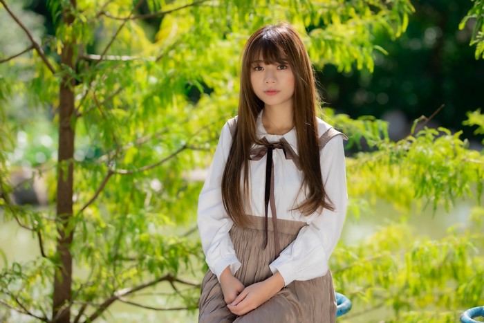 Asian girl sitting in a park