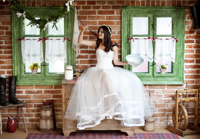 Bride in a white dress tasting food from a spoon
