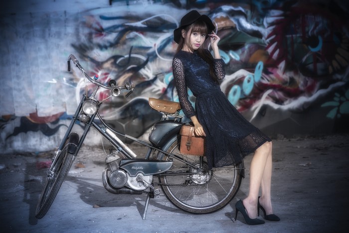 Asian woman in hat and dress with bicycle