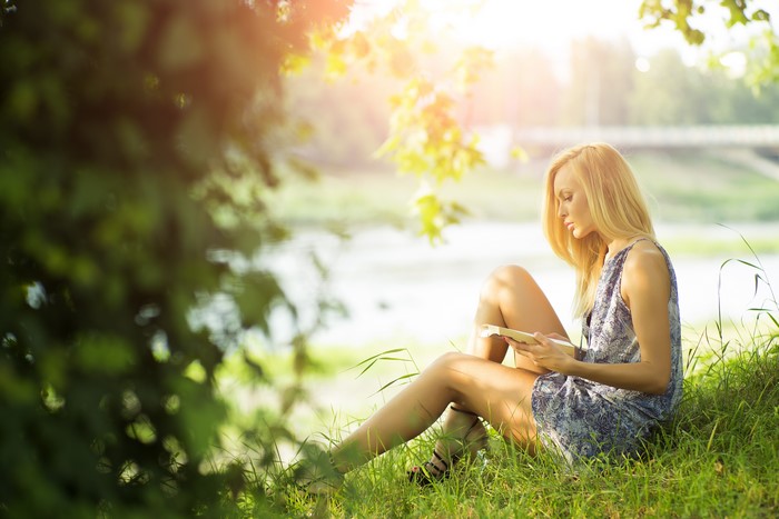 4K Blonde Girl Reading on Grass in Summer