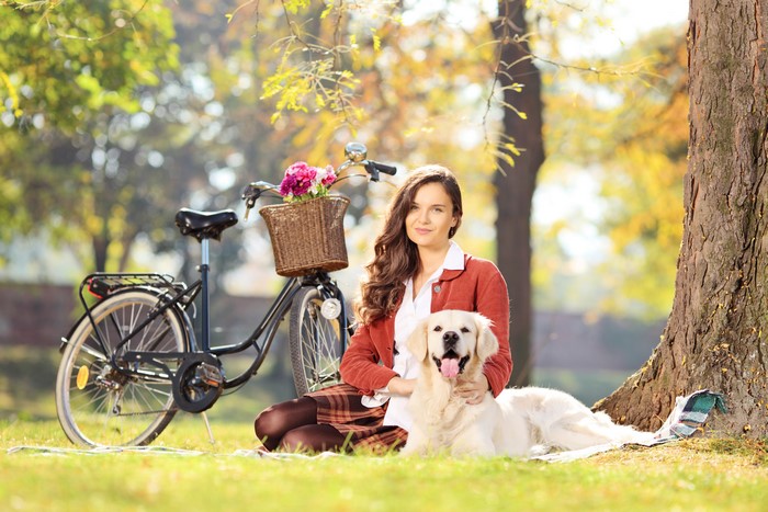 Woman with Golden Retriever and Bicycle in Park