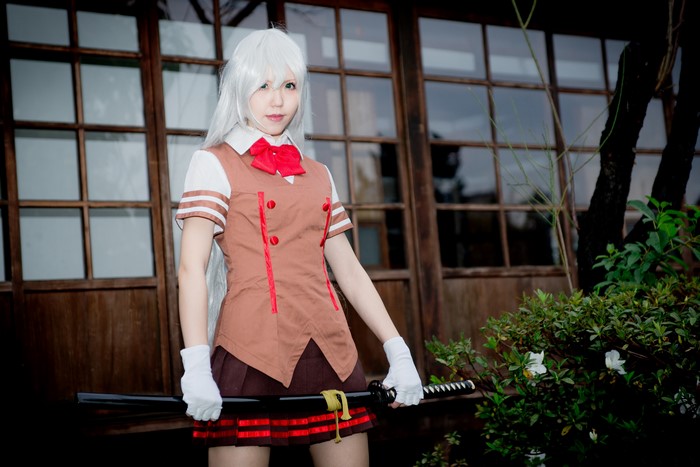 Cosplayer with Katana in front of wooden building