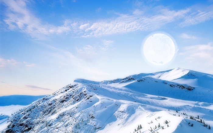 Snowy mountains under a bright moon and blue sky