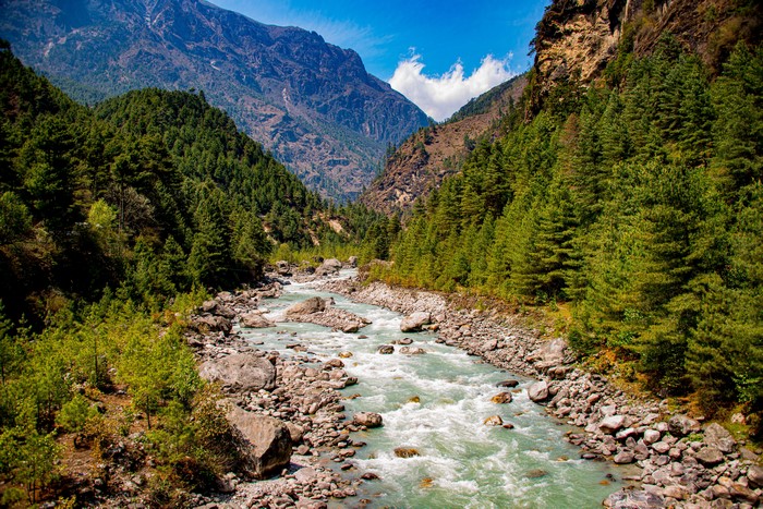 River flowing through a valley in Nepal with mountains and trees
