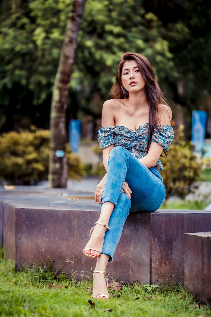 Asian Woman Sitting in Casual Jeans and Blouse