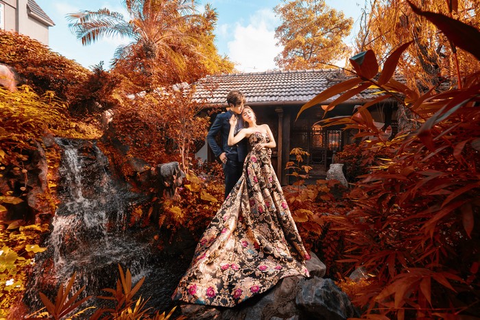 Young Asian couple in formal attire by waterfall