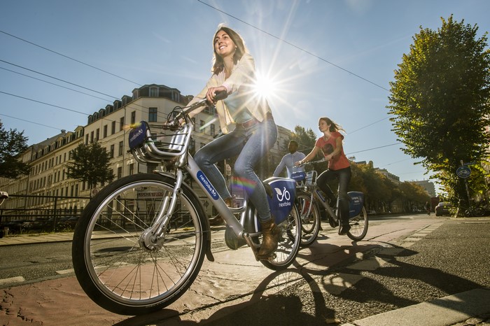 People riding Nextbike bicycles on a sunny street