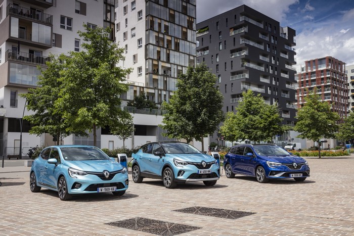 Three Renault cars parked in front of modern buildings