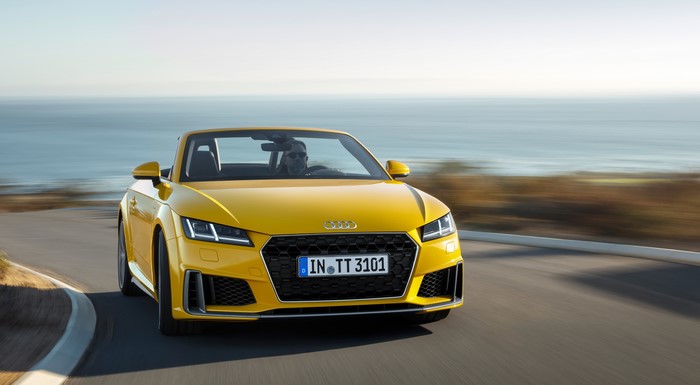 Yellow Audi TT Roadster driving on a coastal road