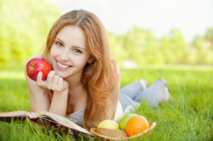 Woman with Apple and Book on Grass
