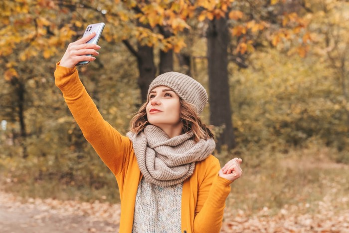 Woman taking a selfie in autumn park
