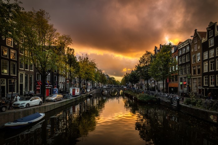 Amsterdam Canal at Sunset with Houses and Bridge