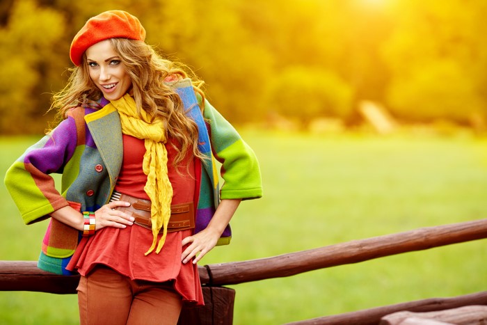 Woman in colorful coat and beret in autumn park