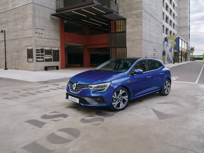 Blue Renault Megane parked in front of a modern building