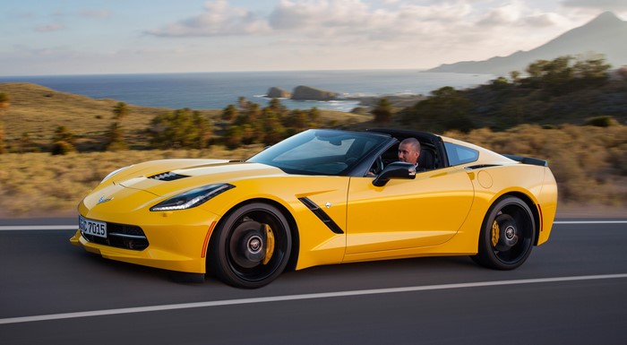 Yellow Chevrolet Corvette Stingray Coupe driving on a road