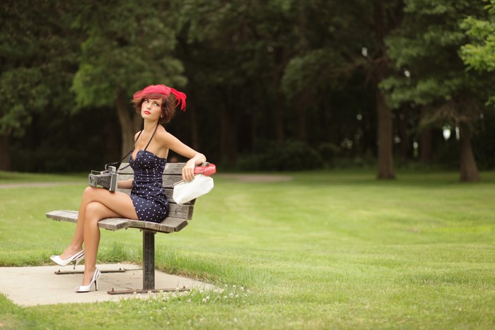 Casey Carlson sitting on a park bench with a camera