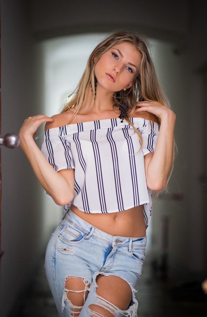 Nadine in ripped jeans and a striped off-the-shoulder blouse