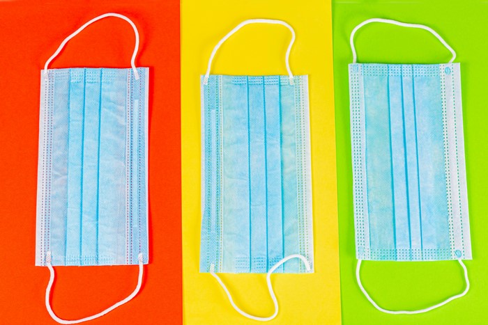Three blue medical masks on colored backgrounds