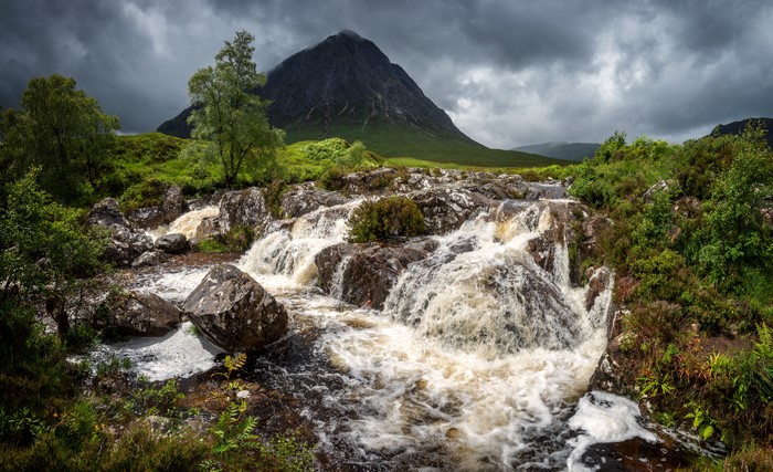 River flowing over rocks with mountain in Glen Etive, Scotland