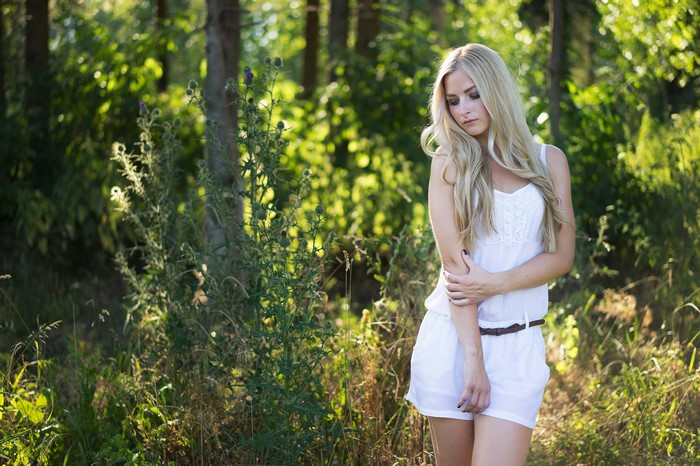 Blonde girl posing in a forest