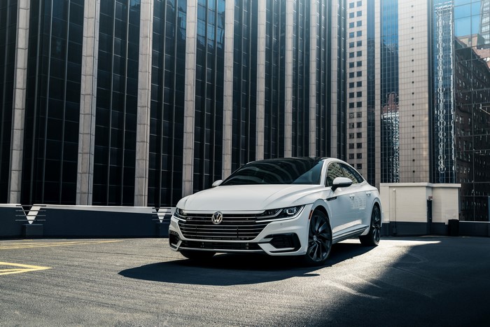 White Volkswagen Arteon R-Line parked in front of modern buildings