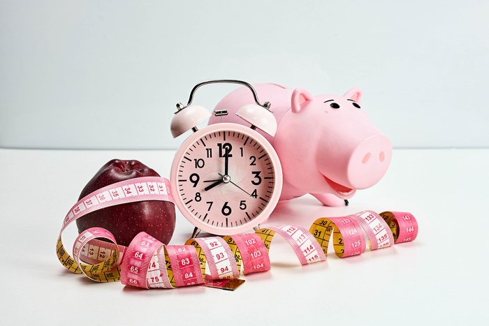Alarm clock, apple, piggy bank, and tape measure