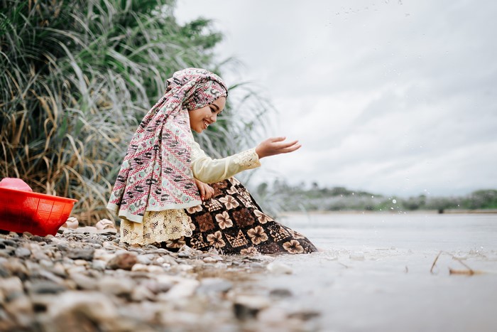 Indonesian woman in traditional clothing by the water