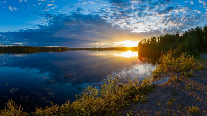 Sunset over a lake in Kuusamo, Finland with a boat
