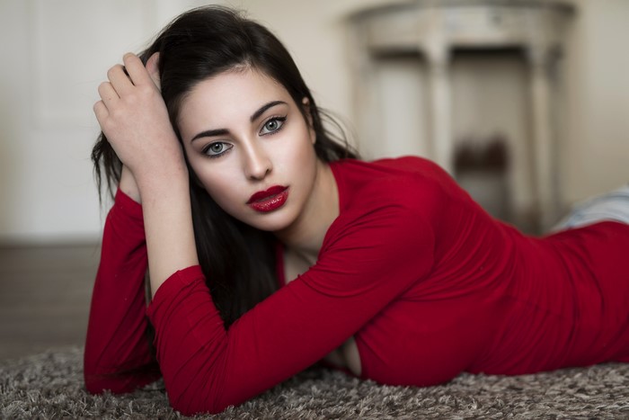 Brunette girl with red lips lying down